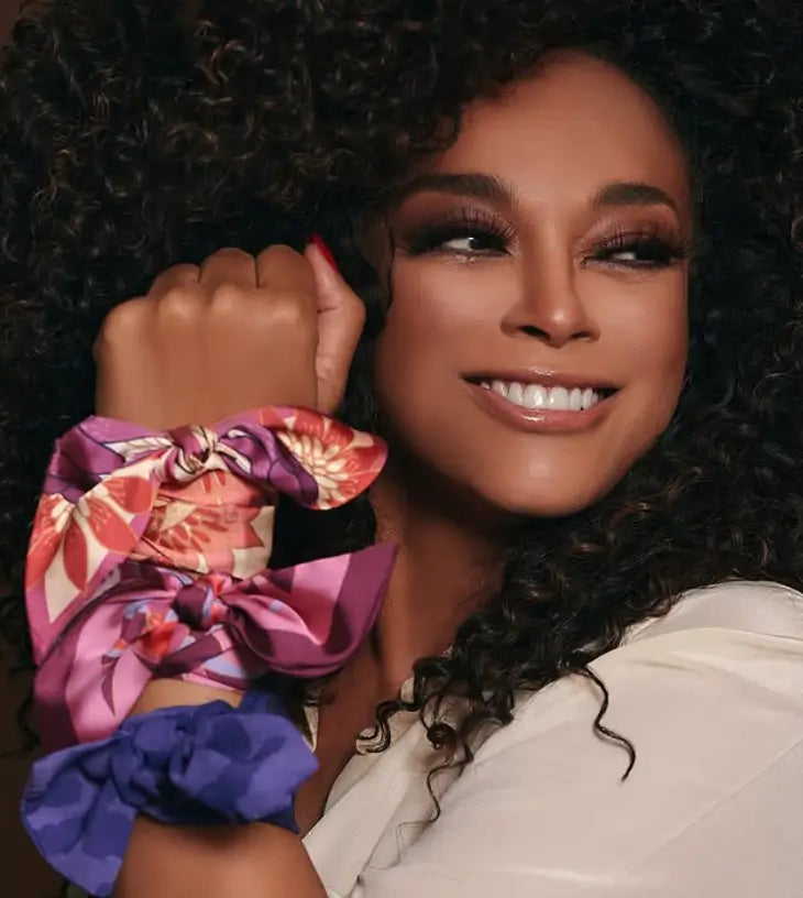 Imagem de modelo sorridente utilizando três lenços Scarf Me no pulso estilo pulseira