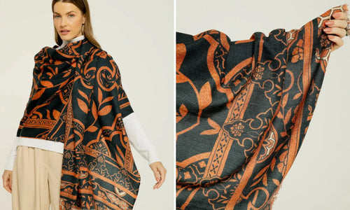 Modelo exibindo cashmere estampado da Scarf Me com detalhes em tons de preto e laranja. Design elaborado e cores vibrantes.