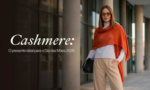 Mulher elegante na rua usando cashmere na cor laranja, combinando com roupa branca e calça bege, representando uma escolha ideal para o Dia das Mães 2026.