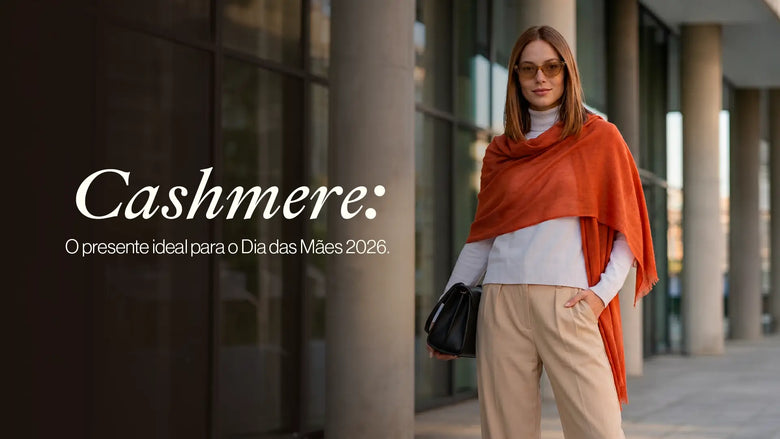 Mulher elegante na rua usando cashmere na cor laranja, combinando com roupa branca e calça bege, representando uma escolha ideal para o Dia das Mães 2026.