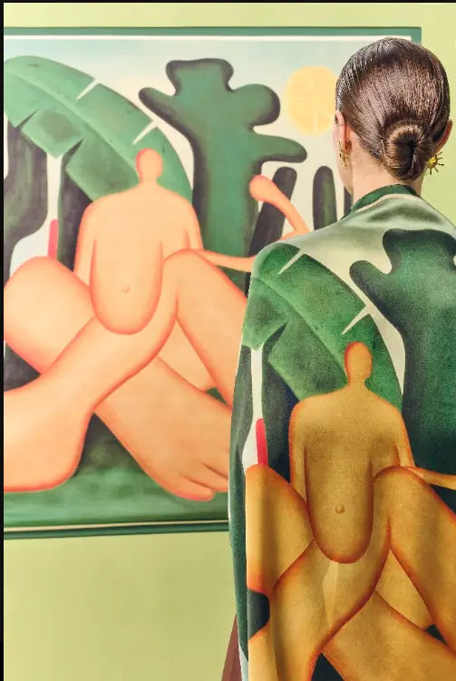 Mulher de costas com o lenço double face Antropofagia encarando a obra de mesmo nome de Tarsila do Amaral.