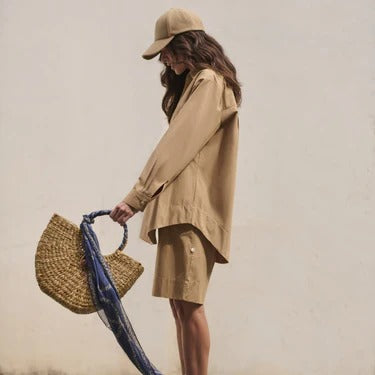 Model with a straw bag and a blue scarf