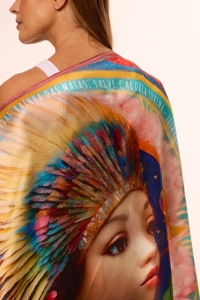 Mulher vista de costas com o lenço Brilho de Jurema com a arte colorida e rica em detalhes. A imagem destaca detalhes de cores vibrantes e um estilo artístico único.