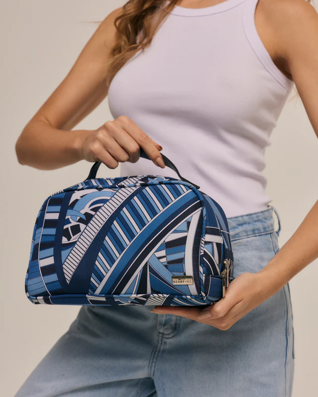 Necessaire estampada em tons de azul segurada por uma modelo